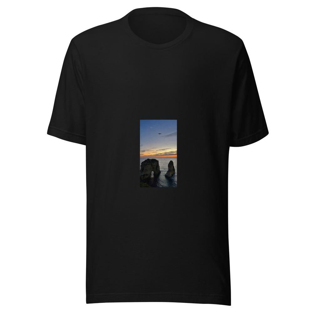 Maglietta unisex nera vista di fronte. Due scogli emergono dal mare: quello a sinistra è attraversato da un arco, mentre sopra l’orizzonte arancio vola la piccola sagoma di un aereo. Mockup del capo completo.