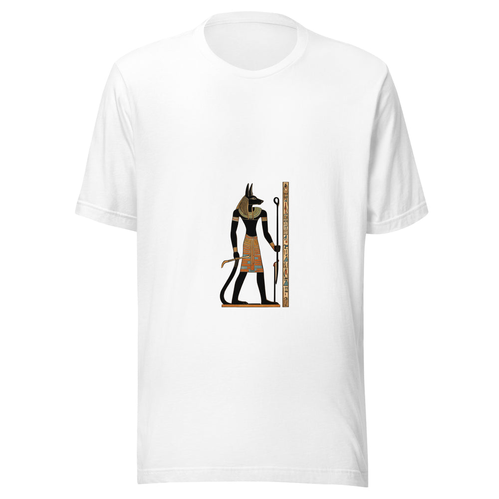 Maglietta unisex bianca vista di fronte. Una figura nera con testa di sciacallo impugna un bastone, tra ornamenti dorati e turchesi e una fascia laterale di simboli. Mockup del capo completo.