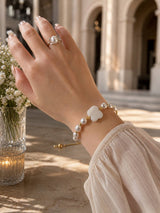 Bracciale di perle bianche con fiore in madreperla — la fotografia in bottega