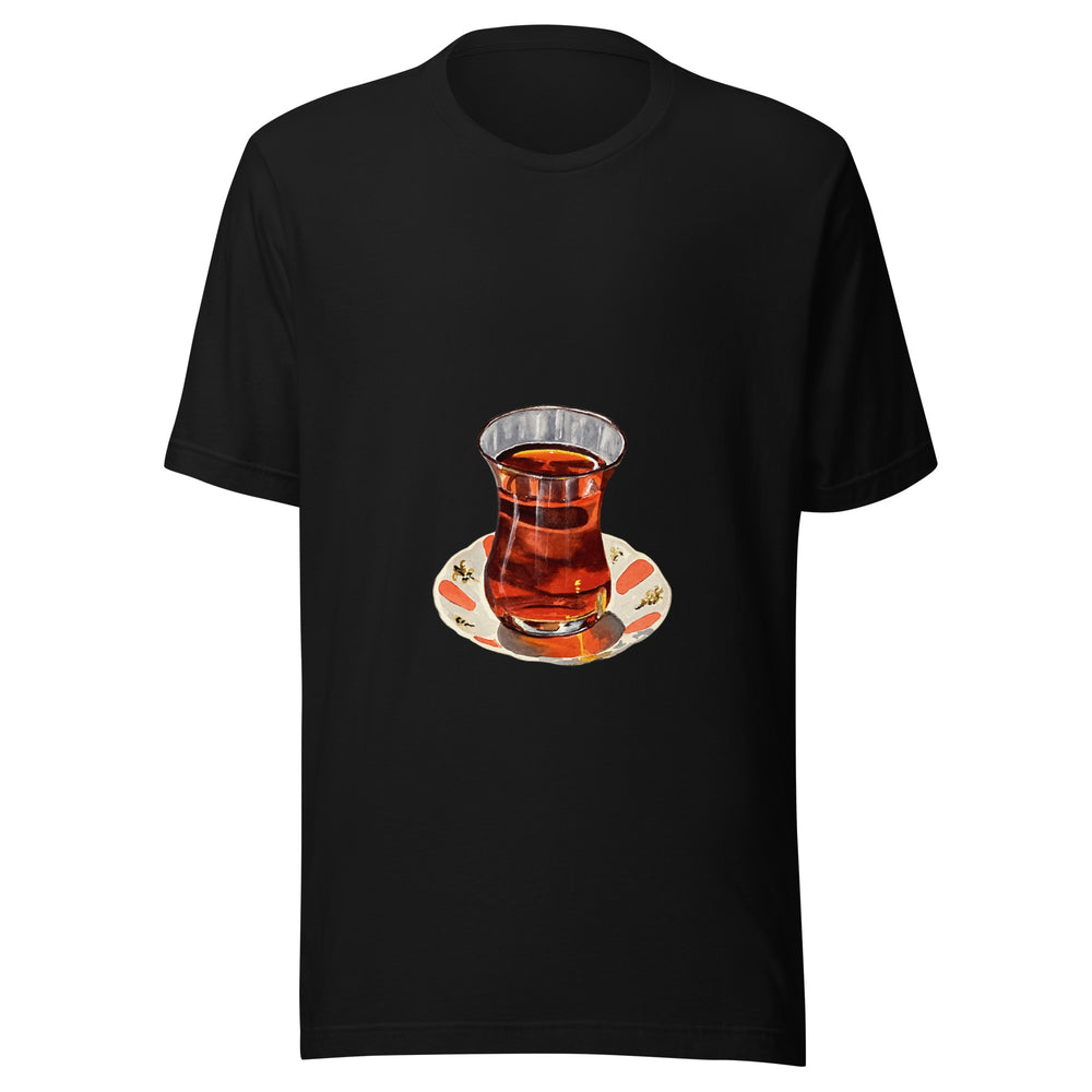 Maglietta unisex nera vista di fronte. Tè ambrato scuro riempie un bicchiere sagomato, appoggiato su un piattino crema con decori corallo. Mockup del capo completo.
