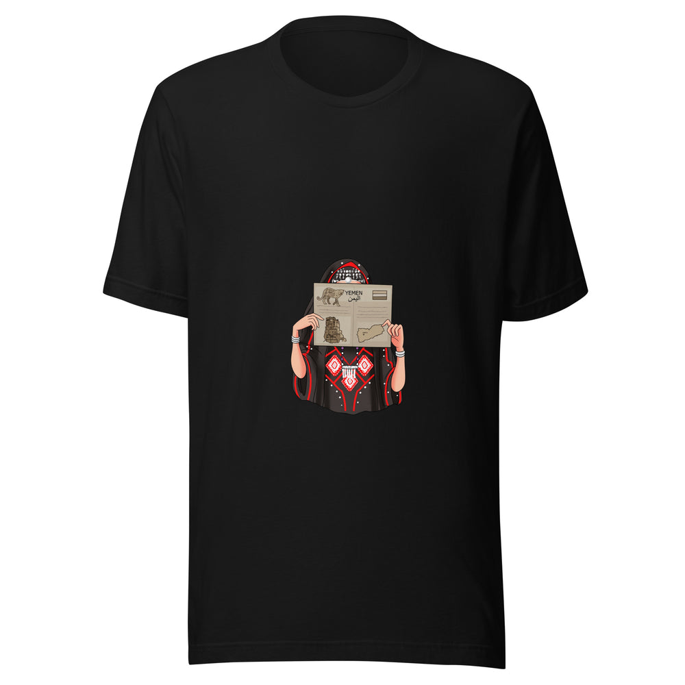 Maglietta unisex nera vista di fronte. Una figura femminile illustrata, vestita di nero e rosso con ornamenti geometrici, tiene davanti al volto un giornale dedicato allo Yemen. Mockup del capo completo.
