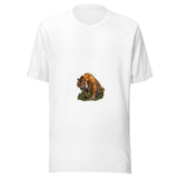 Maglietta unisex bianca vista di fronte. La tigre avanza con la testa bassa e la bocca aperta, tra terra, rami e vegetazione che nascondono parte delle zampe. Mockup del capo completo.