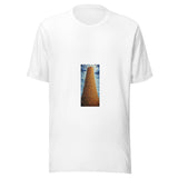 Maglietta unisex bianca vista di fronte. Una torre ocra, composta da numerosi livelli ad arco, sale fra nuvole blu. Mockup del capo completo.